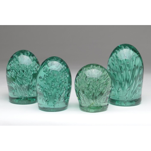 80 - Four Nailsea glass dumps, each encasing a bubble fountain encased in green glass, the largest 14cm, ... 