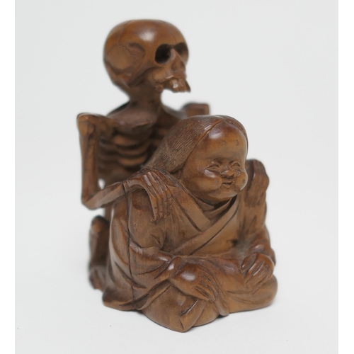 666 - Japanese carved boxwood okimono, formed as a skeleton on the back of a seated man, signed, 7.5cm