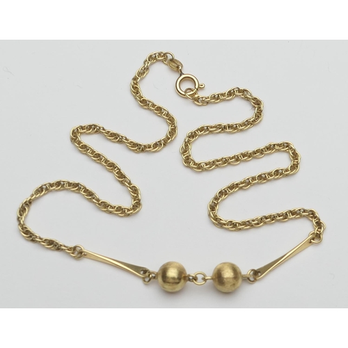 391 - 18ct gold choker necklace, having two textured ball pendants suspended from bar links, on a rope twi... 