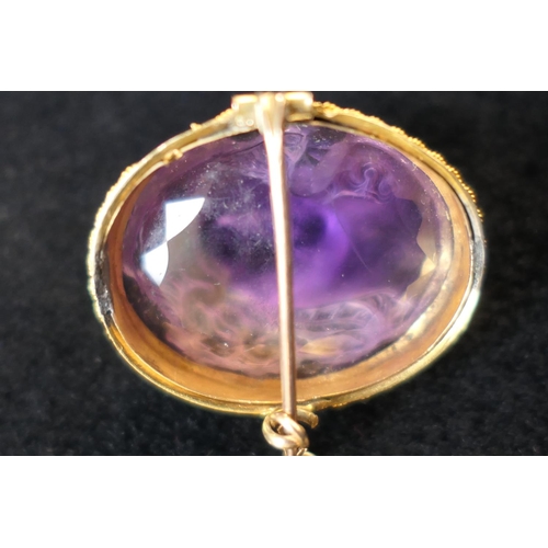 438 - Carved amethyst cameo brooch, worked as the head of Venus, in an unmarked yellow metal mount with sa... 