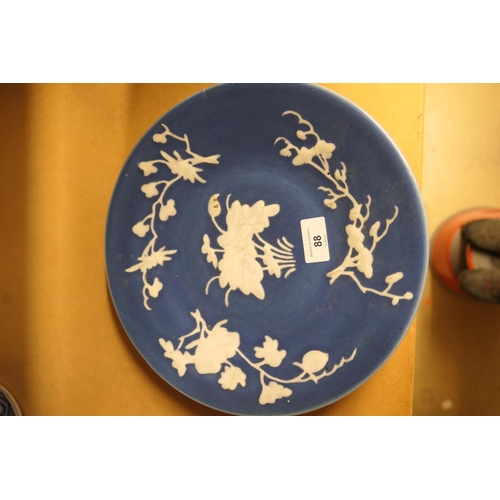 88 - Chinese blue ground dish, 19th Century, slip decorated with white foliate sprays around a lotus cent... 