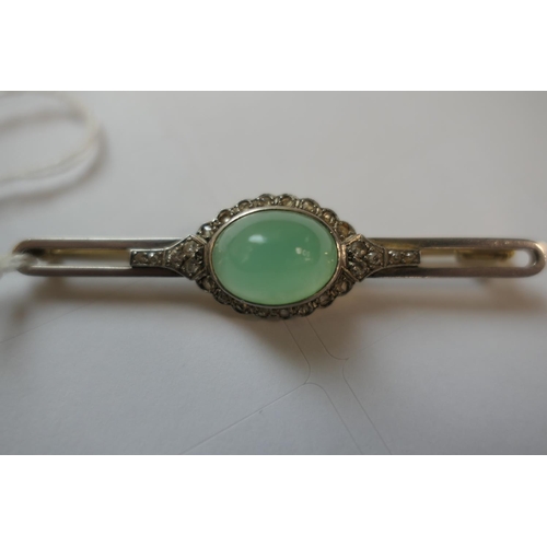 419 - Jade and diamond bar brooch, the celadon green cabochon bordered with rose cut diamonds set in white... 