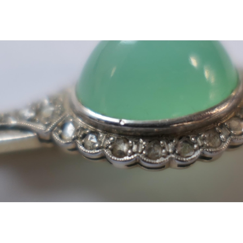 419 - Jade and diamond bar brooch, the celadon green cabochon bordered with rose cut diamonds set in white... 