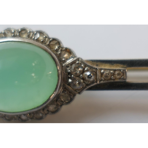 419 - Jade and diamond bar brooch, the celadon green cabochon bordered with rose cut diamonds set in white... 