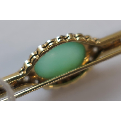 419 - Jade and diamond bar brooch, the celadon green cabochon bordered with rose cut diamonds set in white... 