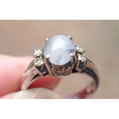 421 - Star sapphire and diamond cluster ring, in 18ct white gold, the cabochon sapphire of approx. 0.3ct, ... 