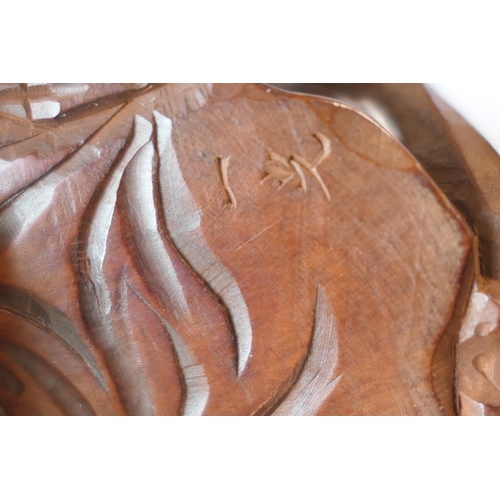 666 - Japanese carved boxwood okimono, formed as a skeleton on the back of a seated man, signed, 7.5cm