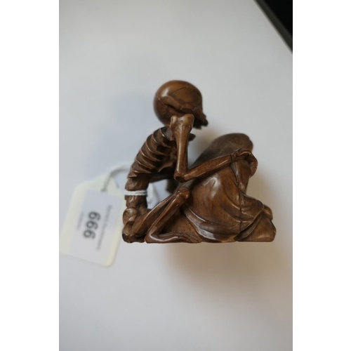 666 - Japanese carved boxwood okimono, formed as a skeleton on the back of a seated man, signed, 7.5cm