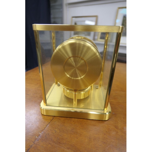 667 - Jaeger Le Coultre brass Atmos clock, mid 1970s, having a white chapter ring with Arabic and baton nu... 