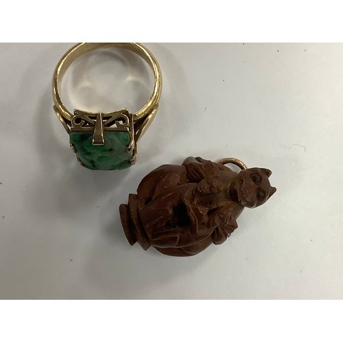 384 - Oriental carved jadeite dress ring in unmarked yellow gold, gross weight 4.3g; also an Oriental monk... 