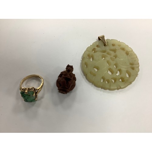 384 - Oriental carved jadeite dress ring in unmarked yellow gold, gross weight 4.3g; also an Oriental monk... 