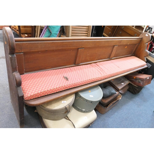 560 - Late Victorian pitch pine pew with a red fabric upholstered pad seat, length 227cm, height to the se... 