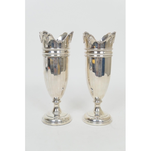 304 - Pair of George V silver vases, Birmingham 1927, each with crenellated top and faceted elongated U-sh... 