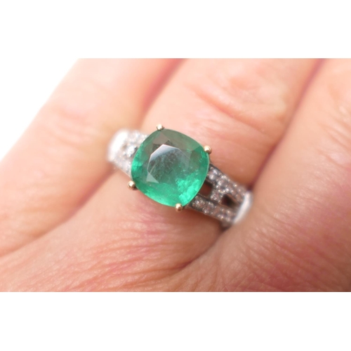 350 - Emerald and diamond cluster ring in 9ct gold, having a cushion cut emerald of approx. 3cts, in a fou... 