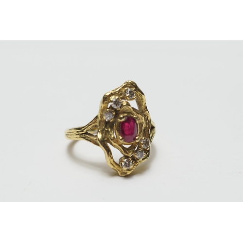 432 - Ruby and diamond cluster ring in 18ct gold, the oval cut ruby of approx. 0.2ct, in a nugget form tex... 