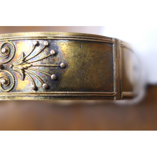 415 - Victorian gold coloured hinged bangle, circa 1880, worked with cannetille decoration, width 16mm, cu... 