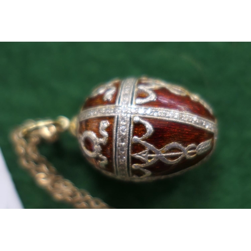 408 - Russian enamelled and diamond egg pendant, with deep red enamelled ground, worked in Imperialist sty... 