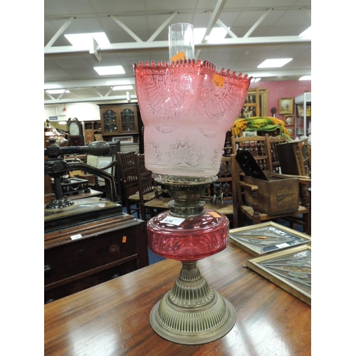 636 - Victorian cranberry glass and brass pedestal oil lamp (NB: wick holder requires re-fitting to reserv... 