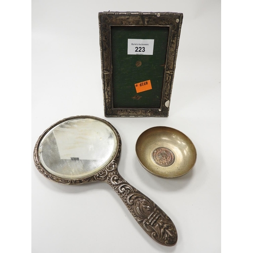 223 - Silver embossed hand mirror, also a damaged silver photograph frame, marks unclear, and a middle eas... 