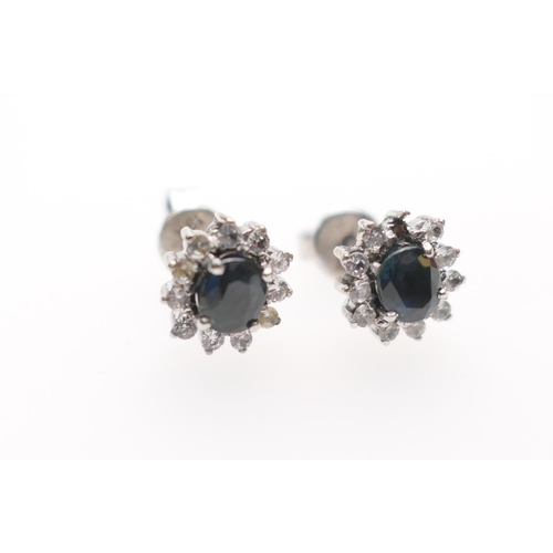 231 - Pair of white and blue sapphire cluster earrings, centred with a cushion cut sapphire bordered with ... 