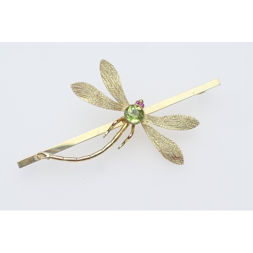 260 - 9ct gold dragonfly bar brooch, centred with a round cut peridot, 6mm diameter, and with ruby eyes, m... 