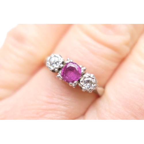 265 - Diamond and ruby three stone ring, the central round cut ruby of approx. 0.5ct, in a claw mount bord... 