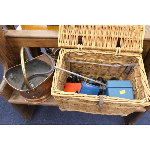 561 - Wicker fishing basket with fixed spool reel and other tackle contents; also a brass helmet shaped co... 