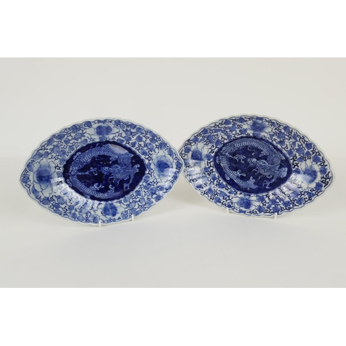 115 - Pair of Japanese blue and white oval dishes, Meiji (1868-1912), each centred with a three toed drago... 