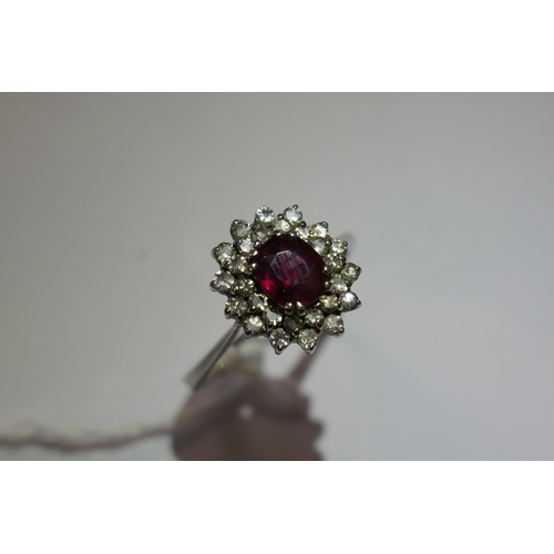 328 - Ruby and diamond cluster ring, the oval cut ruby of approx. 1ct, bordered with small round cut diamo... 