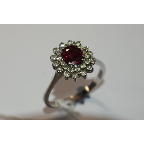 328 - Ruby and diamond cluster ring, the oval cut ruby of approx. 1ct, bordered with small round cut diamo... 