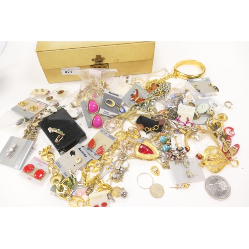 421 - Assorted costume jewellery in a cream jewellery box