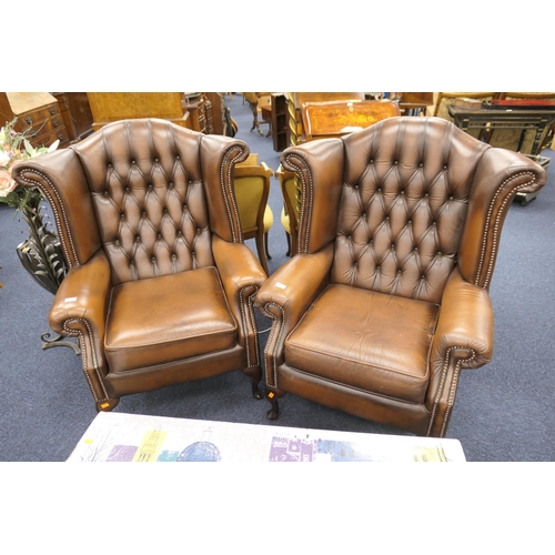 750 - Pair of brown leather upholstered wing armchairs