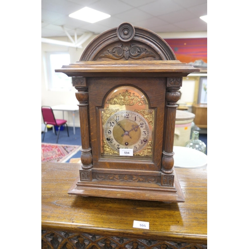 594 - German carved oak cased chiming mantel clock, height 47cm, width 33cm