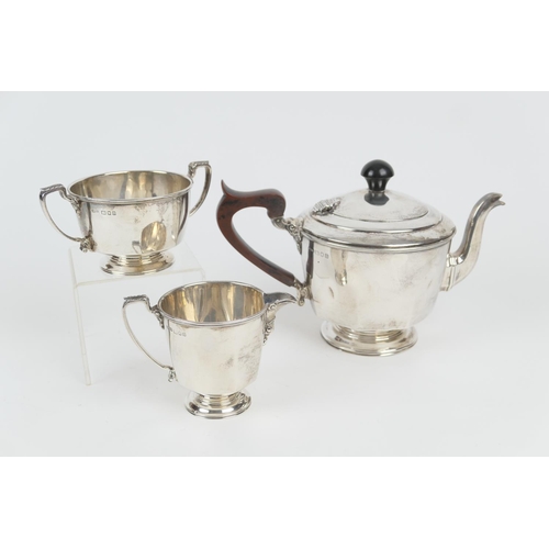 106 - George VI silver three piece tea service, London 1937, plain form, the teapot with replaced ebonised... 