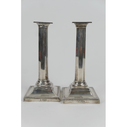 112 - Pair of late Victorian silver candlesticks, by Martin Hall & Co., Sheffield 1896, with square nozzle... 