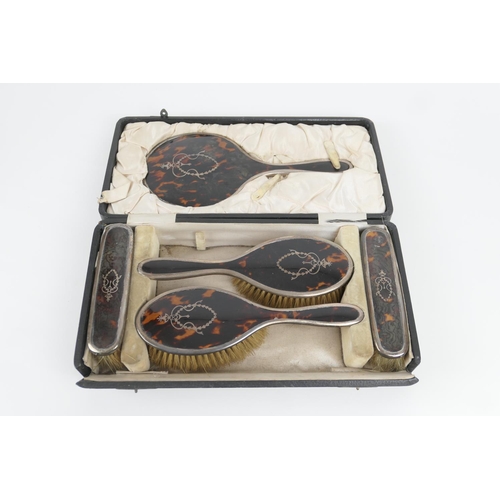 80 - George V silver and pique tortoiseshell vanity set, Birmingham 1919, comprising hand mirror, two hai... 