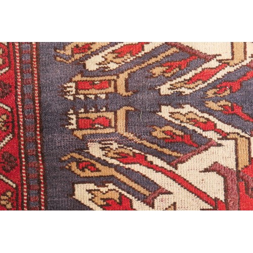 585 - Kazak rug, having three medallions in fawn, red and blue against an abrashed blue field with red run... 