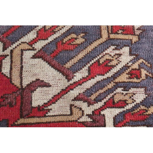 585 - Kazak rug, having three medallions in fawn, red and blue against an abrashed blue field with red run... 