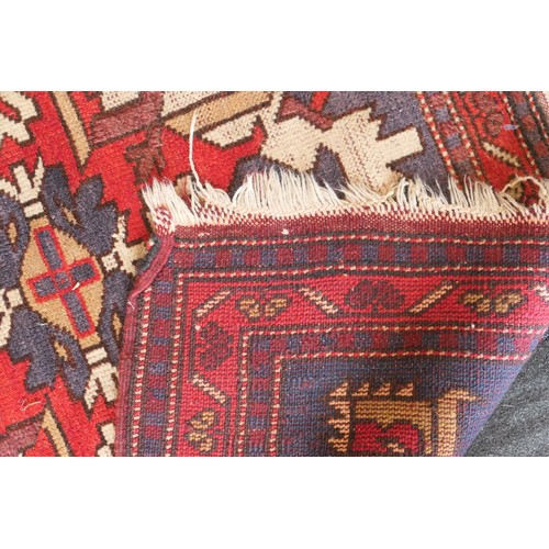 585 - Kazak rug, having three medallions in fawn, red and blue against an abrashed blue field with red run... 