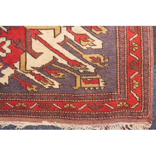 585 - Kazak rug, having three medallions in fawn, red and blue against an abrashed blue field with red run... 