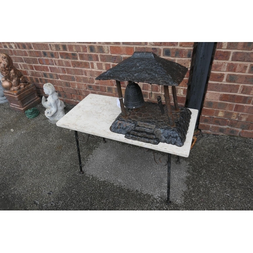 616 - Cast metal model of a Japanese temple bell and a limestone topped metal framed small table (2)