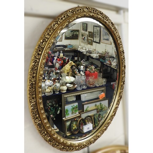 78 - Oval bevelled edged and ornamental gilt framed wall mirror