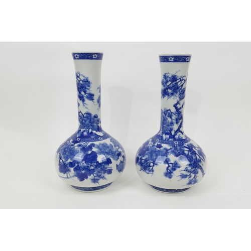 23 - Pair of Japanese blue and white bottle vases, Taisho (1912-26), decorated with peony, fir and chrysa... 