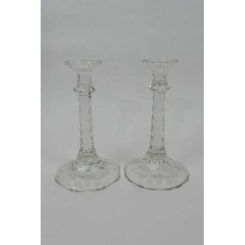 25 - Pair of Regency style cut glass candlesticks, with multi-faceted column over a shaped circular base,... 