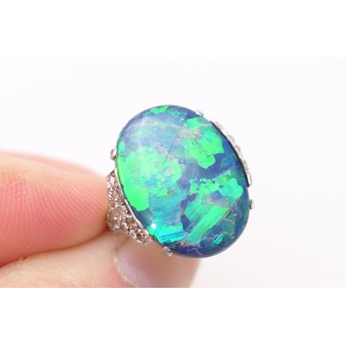 338 - Black opal and diamond ring, having a cabochon opal doublet of approx. 20mm x 16mm, the shoulders se... 