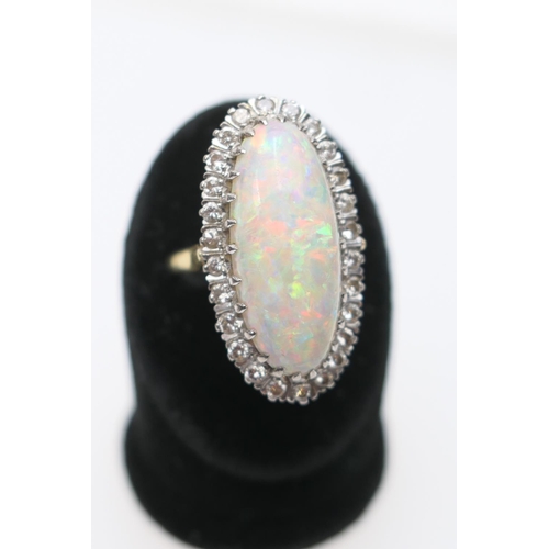 394 - Opal and diamond cluster ring, centred with a cabochon opal, 25mm x 10mm, depth approx. 13mm, in an ... 