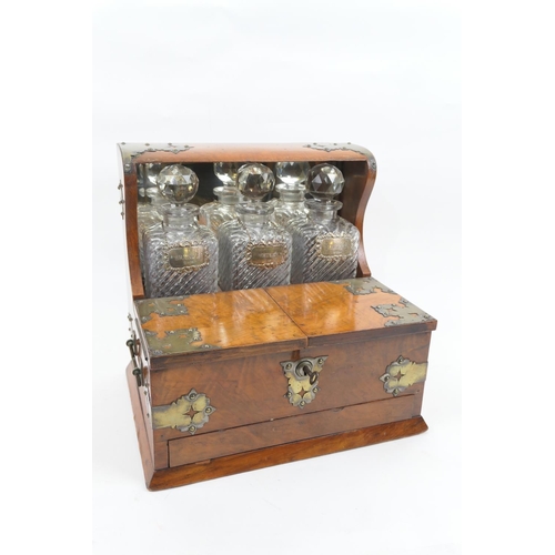 698 - Victorian walnut and brass mounted tantalus, circa 1850-70, having three wrythen moulded glass squar... 