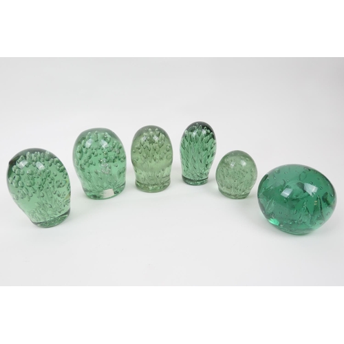 82 - Six Victorian green glass oval and spherical dumps, each encasing a myriad of bubbles, the tallest 1... 