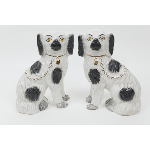 85 - Pair of Victorian Staffordshire spaniels, finished in black and white with gilt chain and padlock, h... 