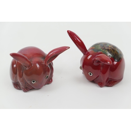 89 - Two Bernard Moore flambe rabbits, grazing, both with original glass eyes, one having a mottle glazed... 